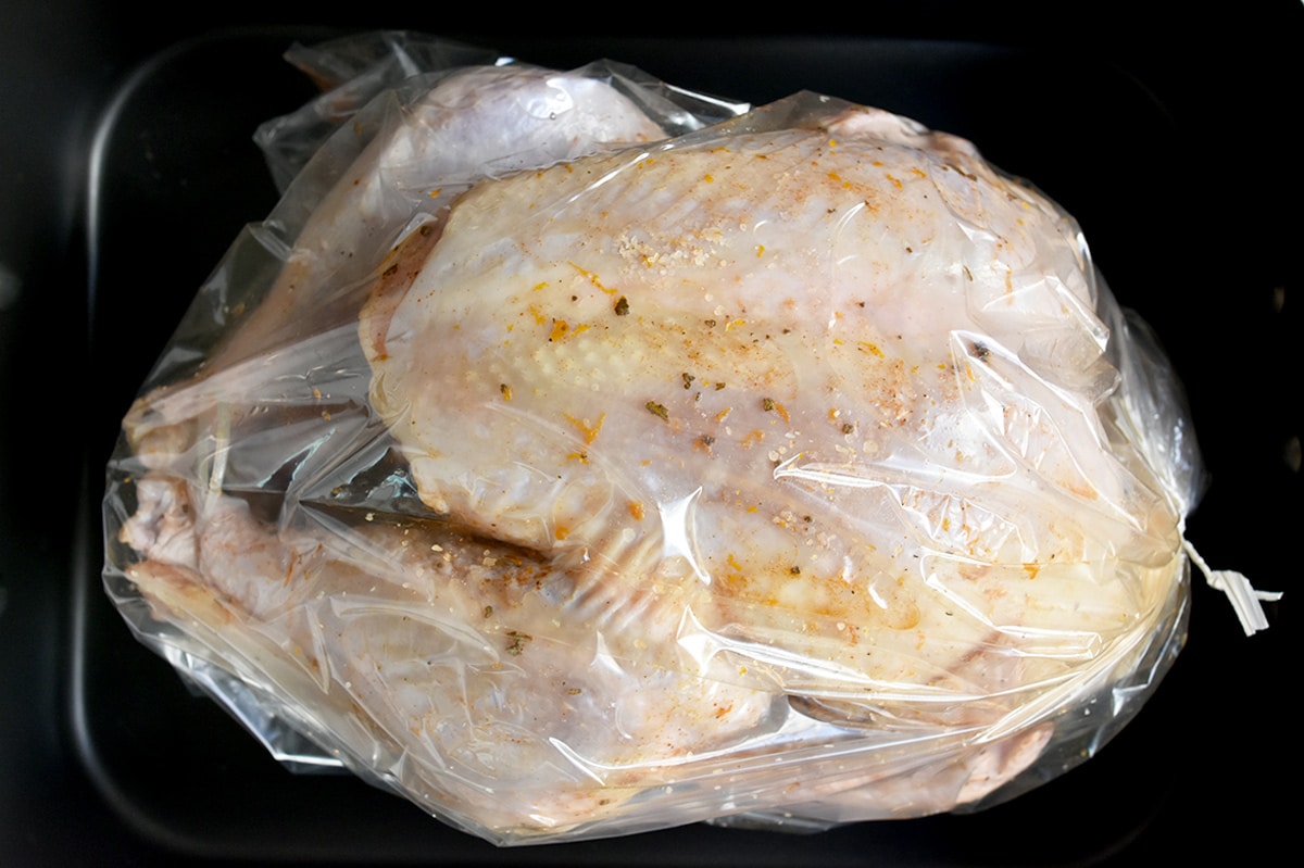 Raw turkey in bag after salt mixture is rubbed on it.