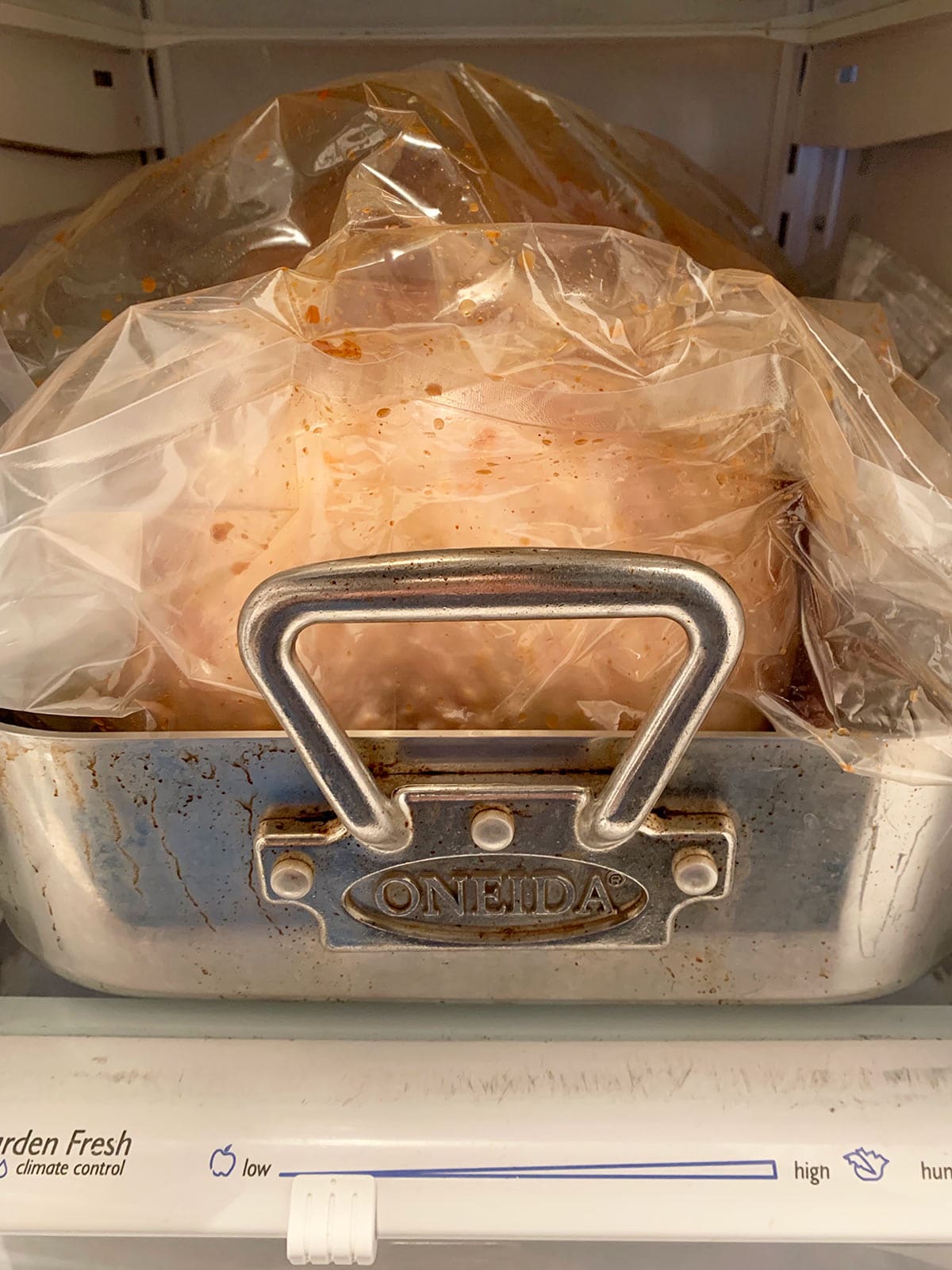 Whole raw brined turkey in bag in its roasting pan, in the refrigerator.