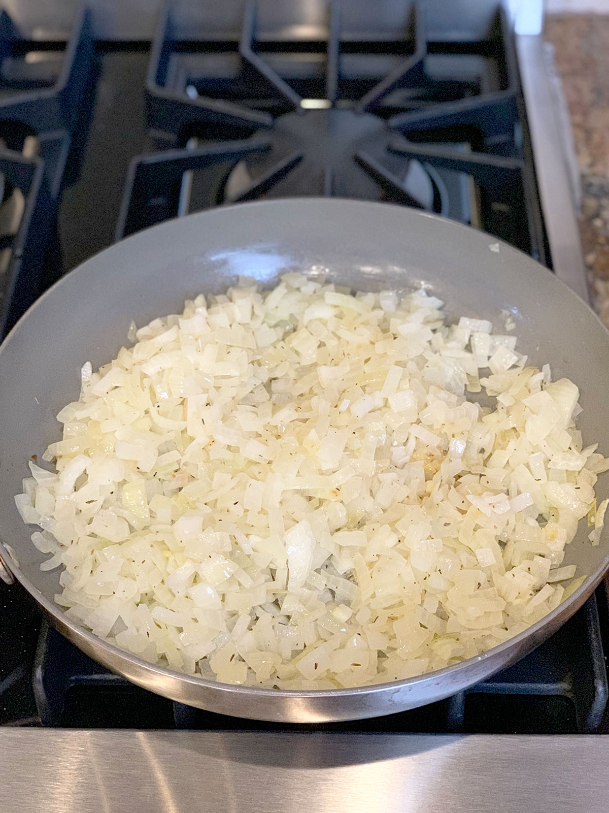 Sauteed onions in frying pan on stove top.