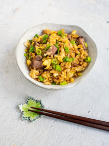 bowl of beef fried rice with wooden chop sticks