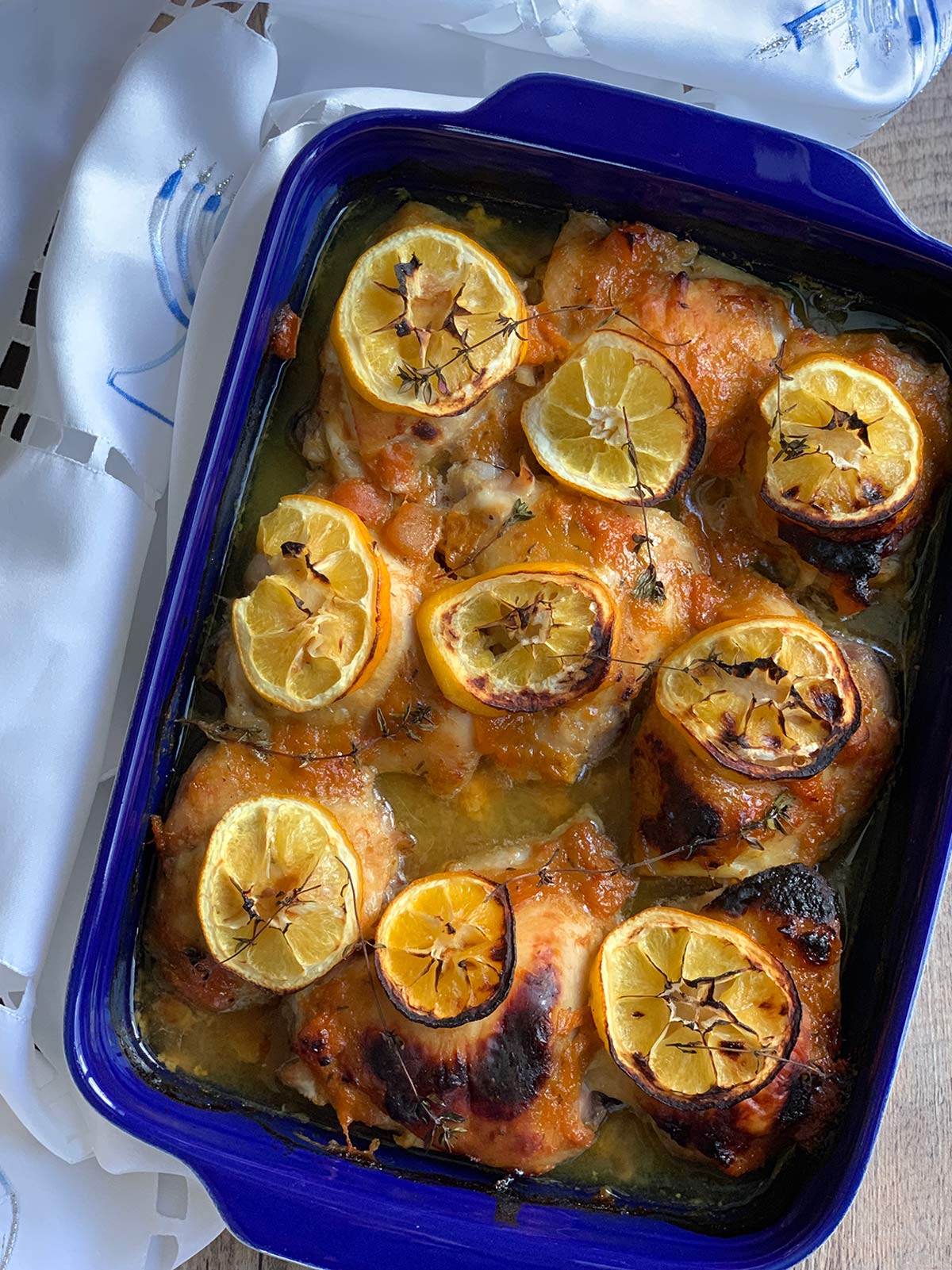 Baked apricot jam chicken in blue pan baking dish. 