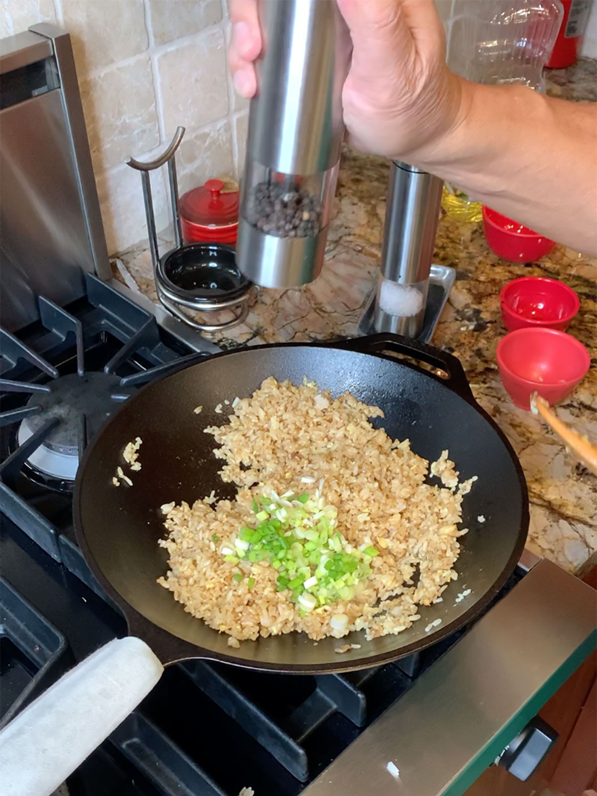 Add green onions and black pepper to rice mixture in wok.