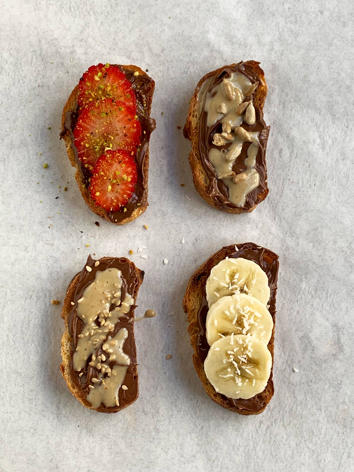 4 mini toasts with various toppings on the nutella.