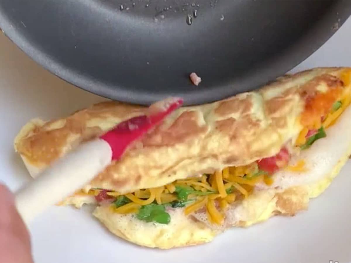Omelette going from pan to plate and folding in half in the process.