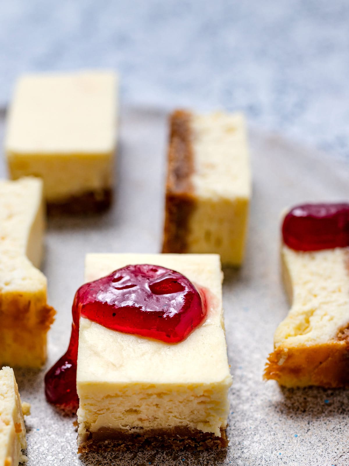 Cheesecakes bars on a platter with jam on top.