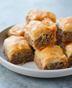 Baklava on a tan rimmed platter.