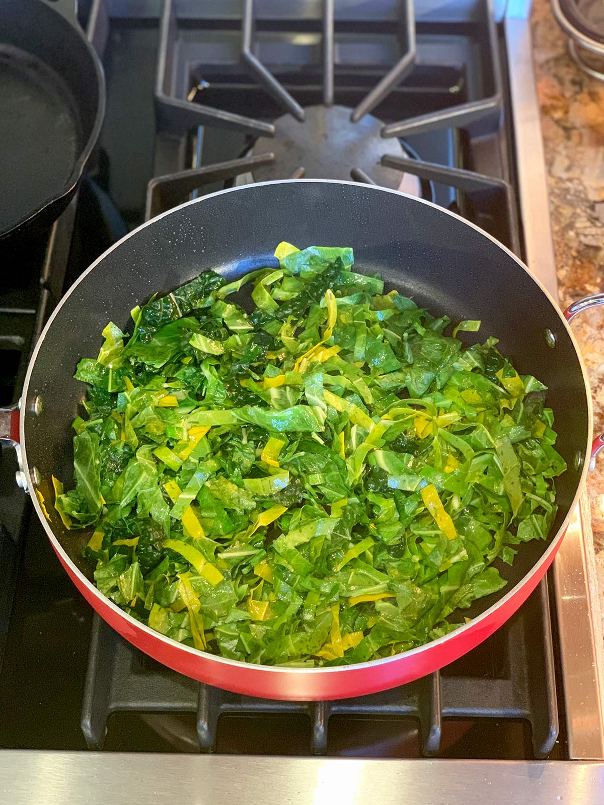 Sliced dark leafy greens in the saute pan.
