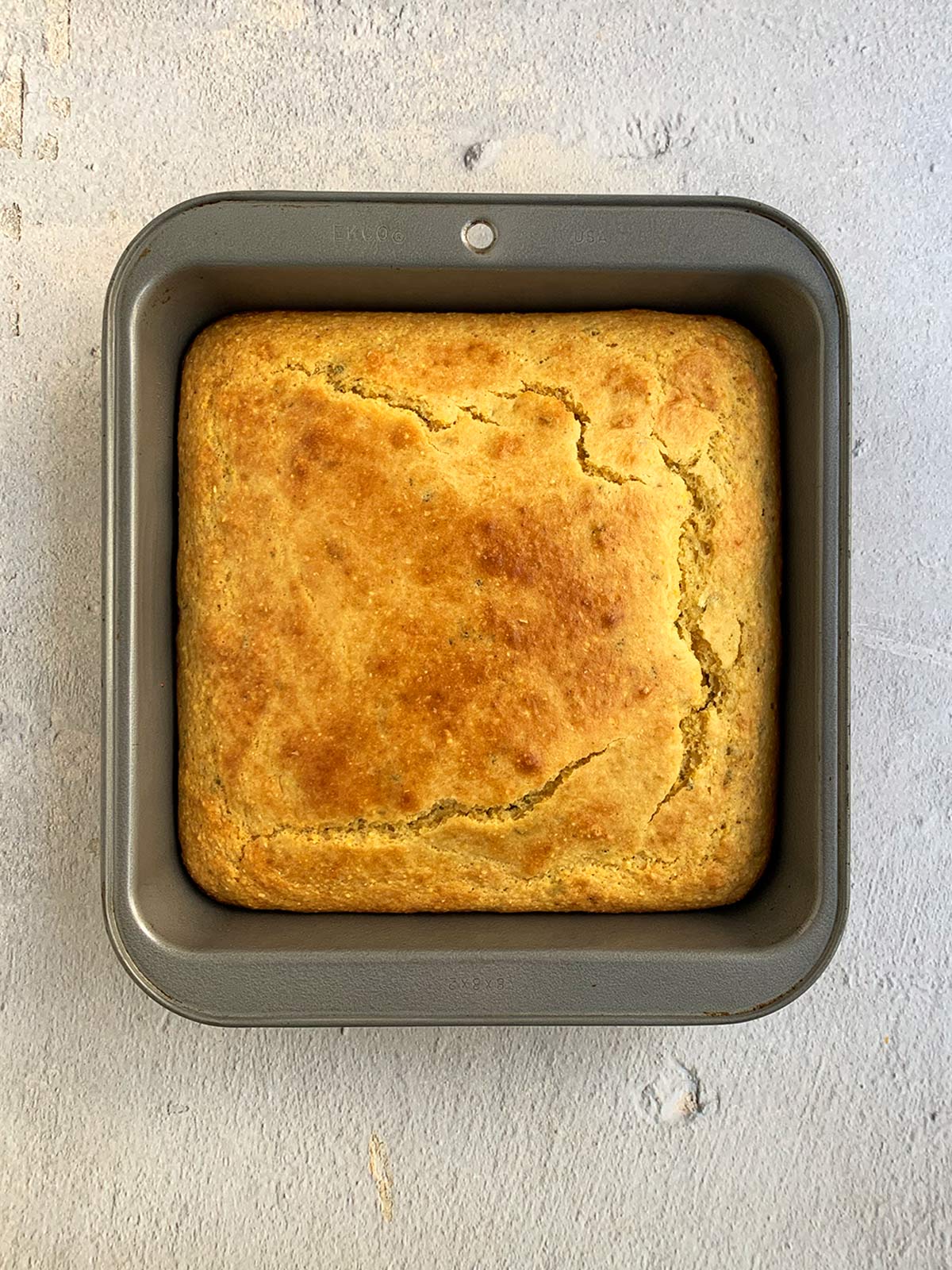 Baked cornbread in grey pan ready to eat.