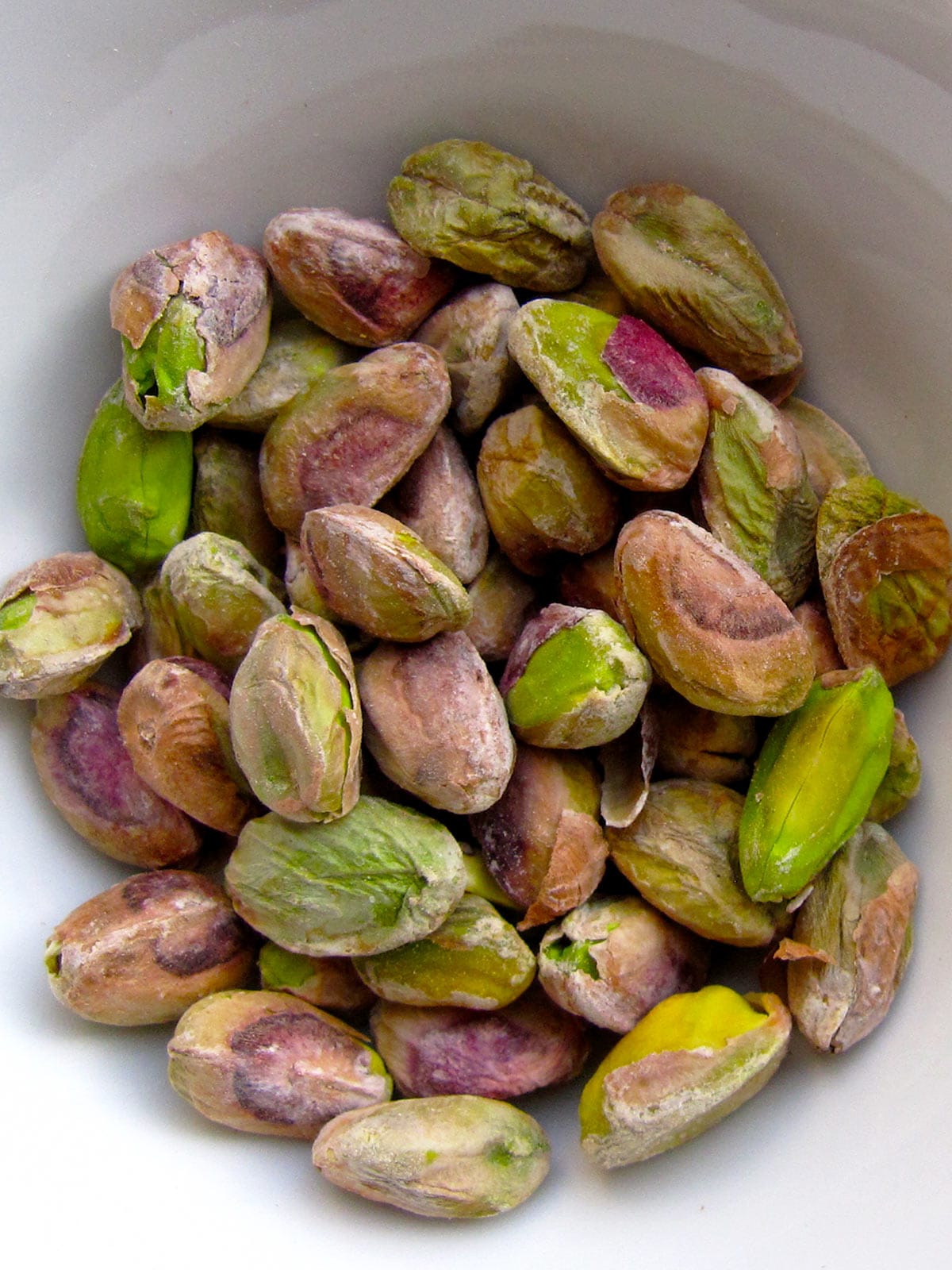 Pistachios in a white bowl.
