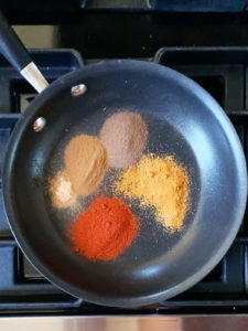Pre-ground spices in a small frying pan.