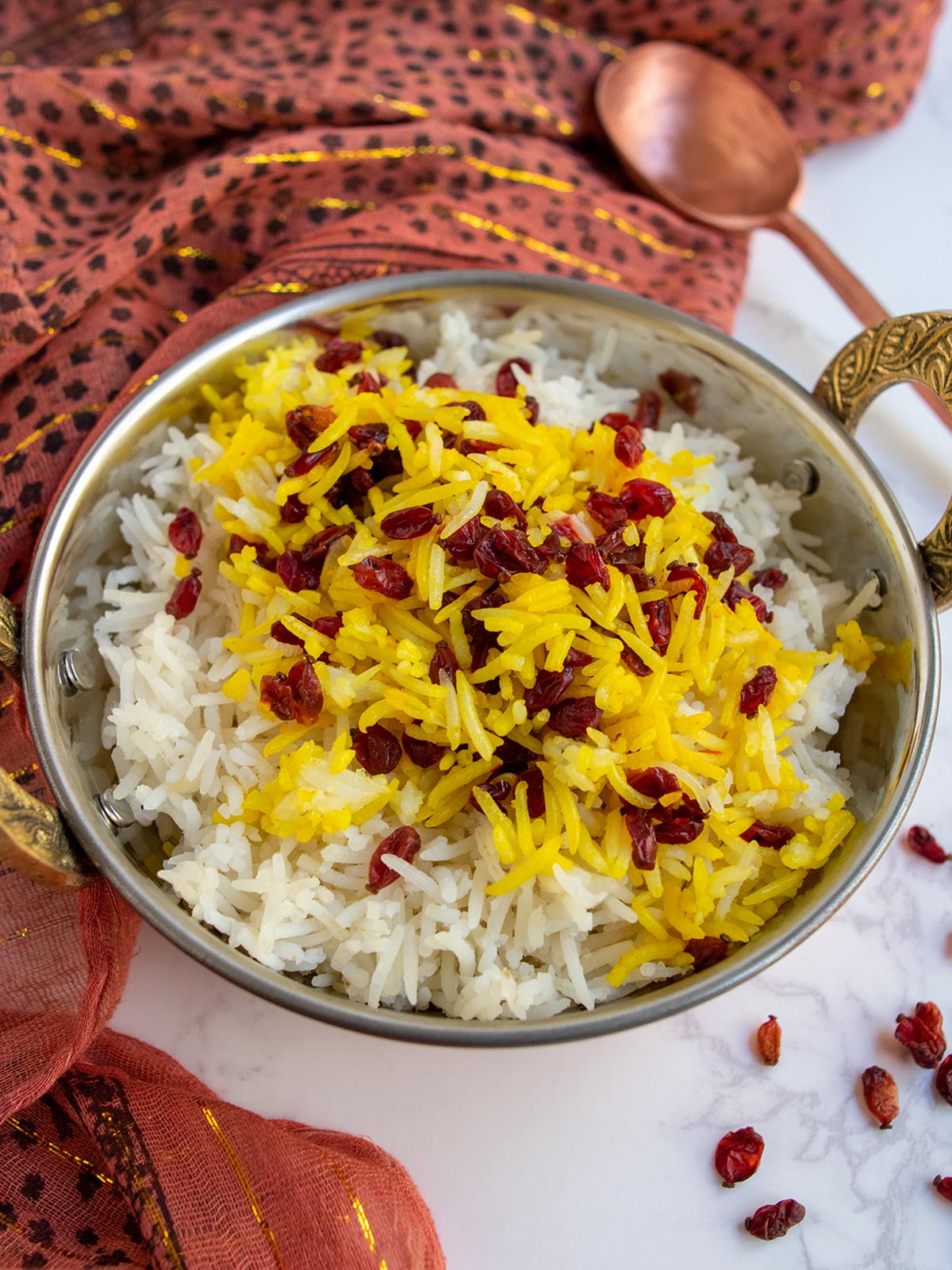 Instant Pot Barberry Rice in copper bowl with copper spoon and an Indian print scarf.