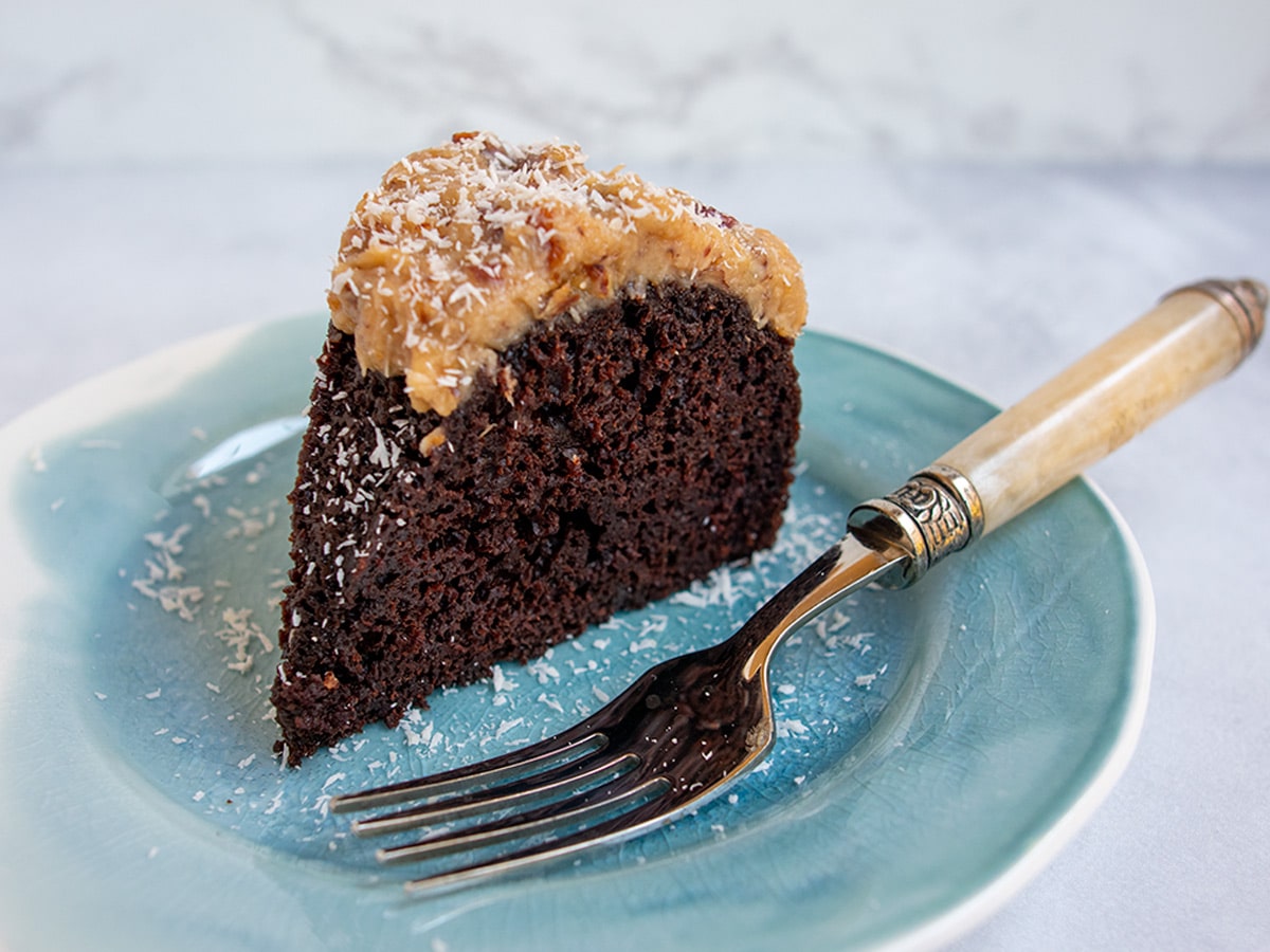 Slice of chocolate Bundt cake with a fork on a blue plate.