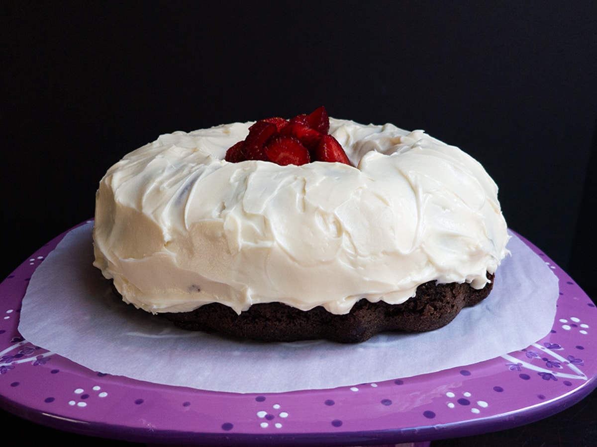Chocolate cake with cream cheese frosting spread all over.