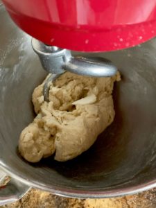 Adding butter to dough in stand mixer.