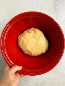 Babka dough in red bowl ready to rise.