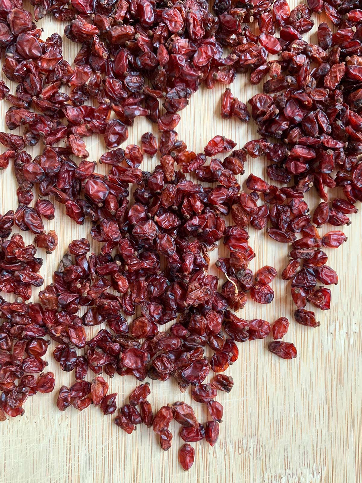 Barberries on a bamboo cutting board.