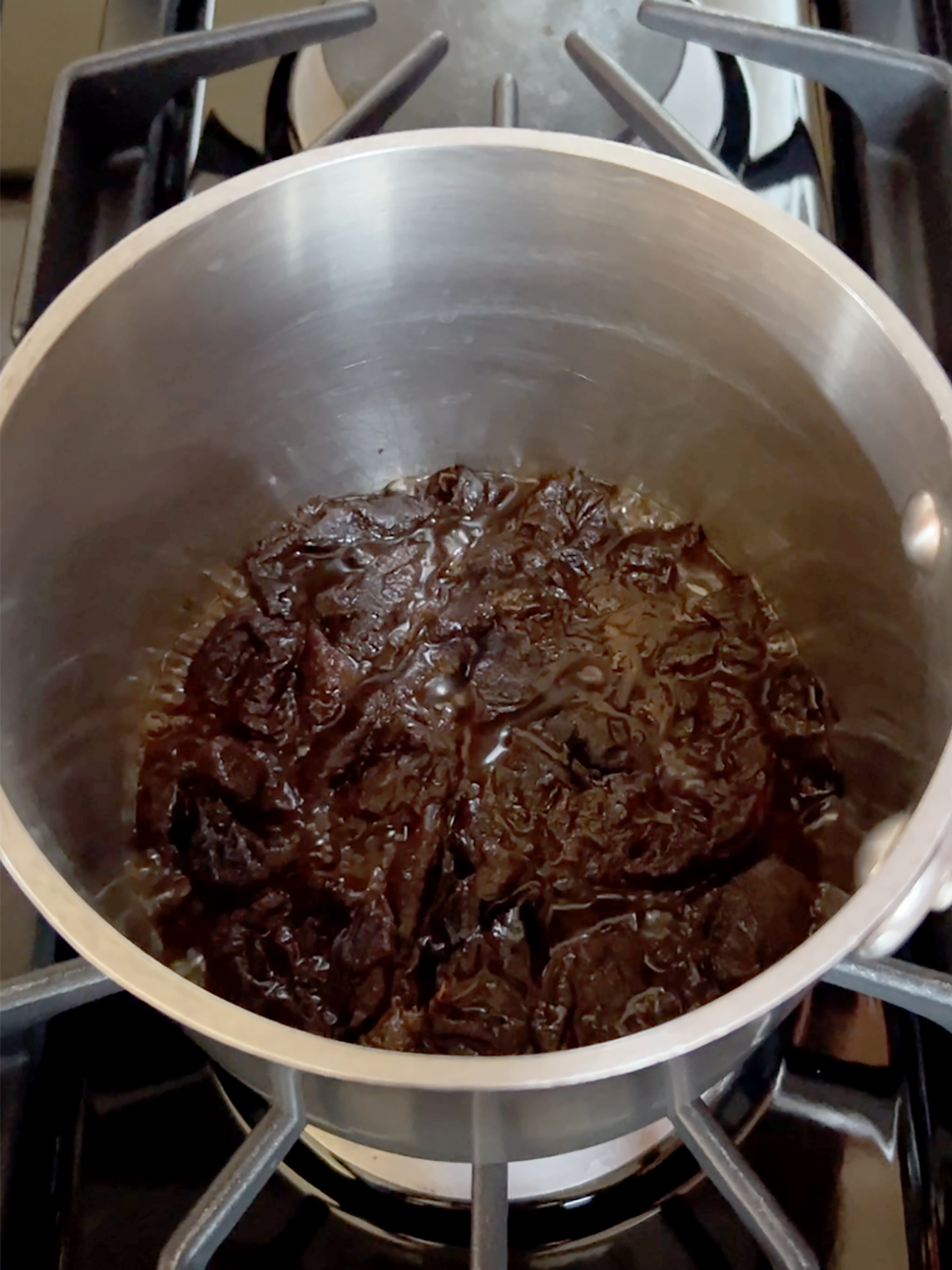 Prunes in pot with most of the water boiled away.