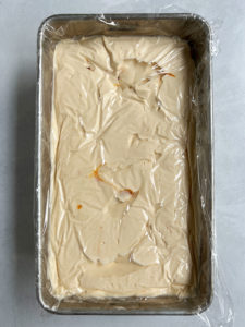 Loaf pan topped with saran wrap and ready to go in the freezer.