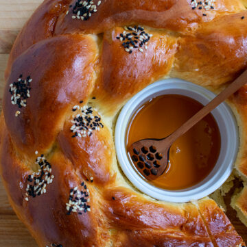 Round challah with a honey ramekin in the center.