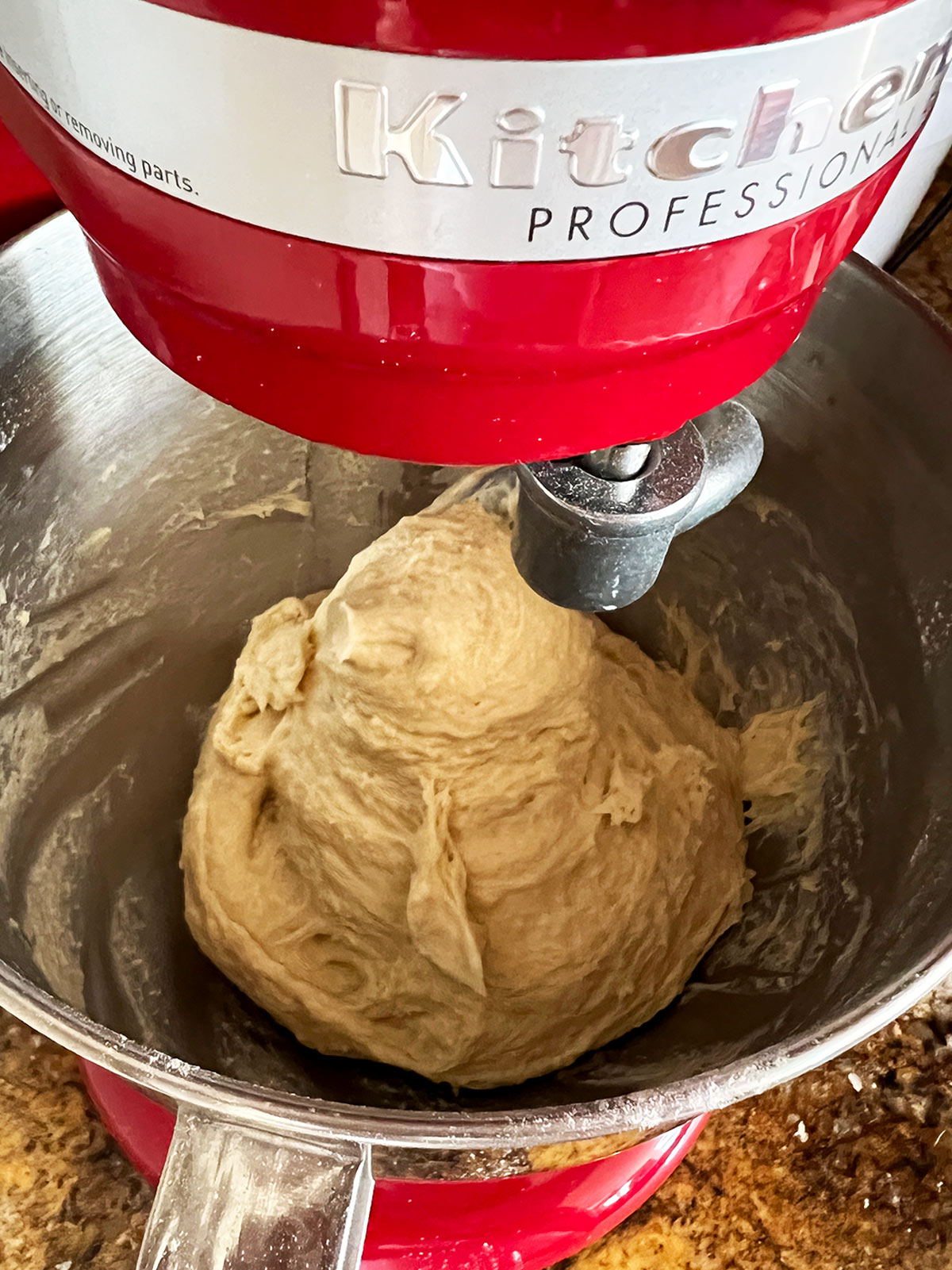 Challah dough kneaded in bowl of stand mixer ready to be removed.