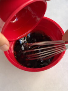 Whisking in the olive oil to the pomegranate molasses dressing.