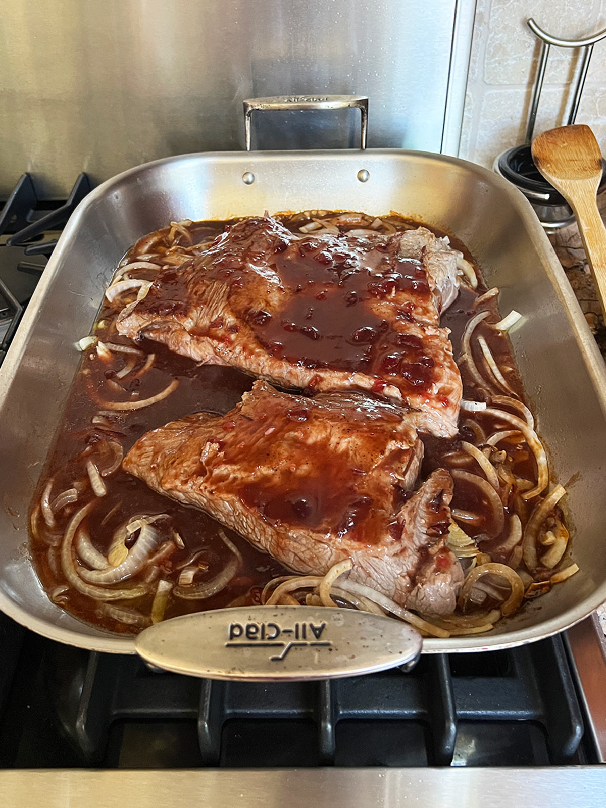 Sauce poured over the brisket in the roasting pan and ready to go in the oven.