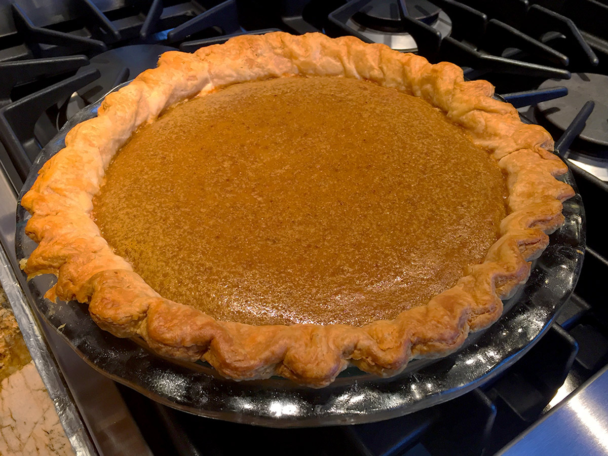 Pumpkin pie cooling on the stove top.