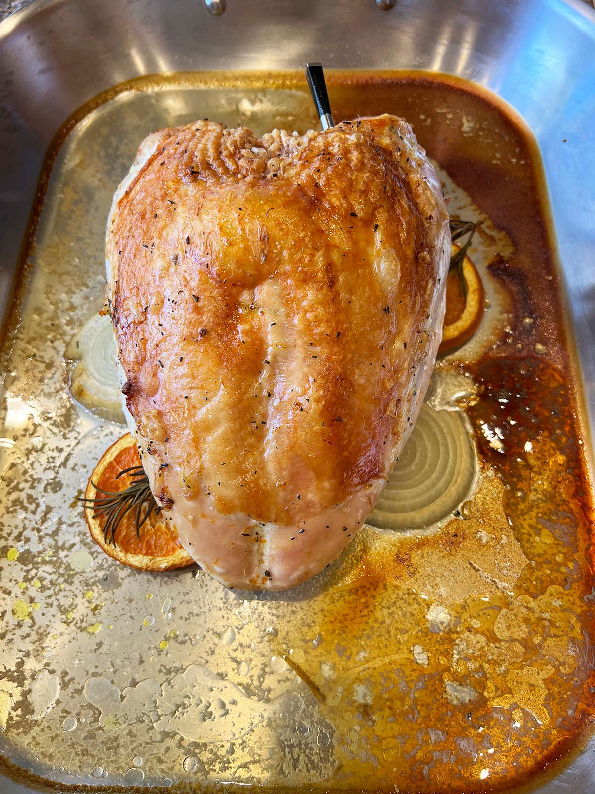 Turkey breast roasted in pan but out of the oven with the probe still inserted.