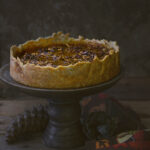 Side view of a pumpkin pecan pie from Family Spice blog.