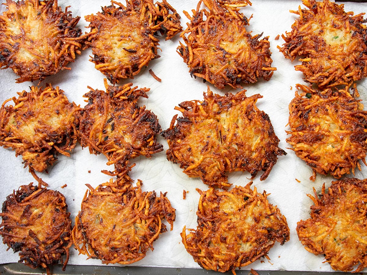 Crispy potato latkes on paper towels and salted after coming out of the frying pan.