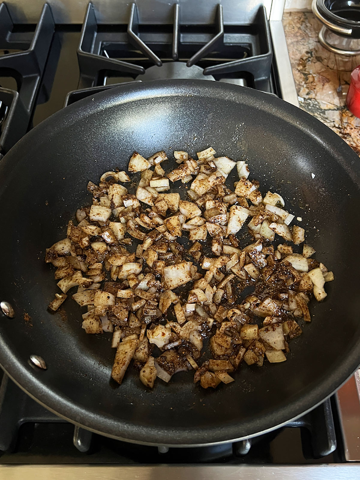 Onions and spices mixed together in the fry pan.