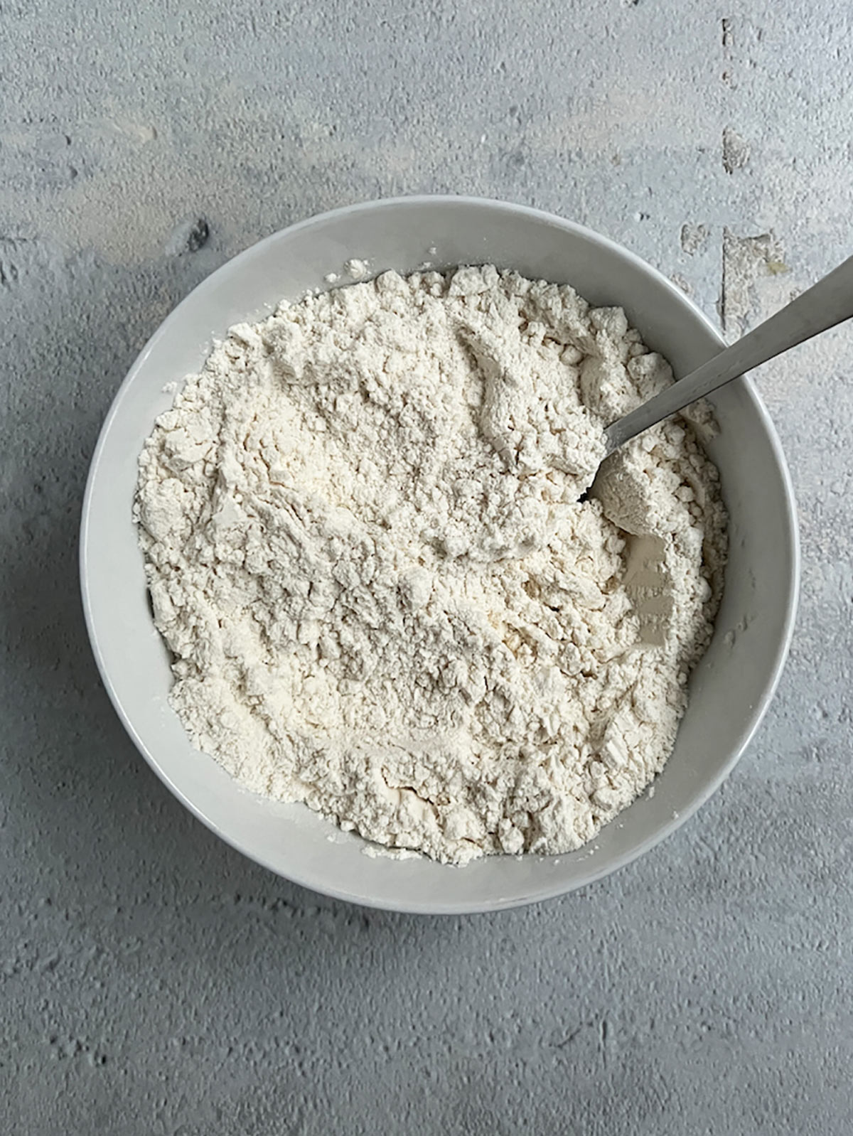 Flour for banana bread mixed in white bowl.