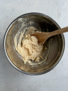 Creamed butter and sugar in a bowl with wooden spoon.