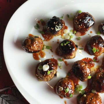 Korean meatballs on a white plate with a red napkin in the background.