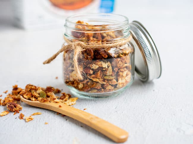 Matzo granola in a jar and wooden spoon on the side.
