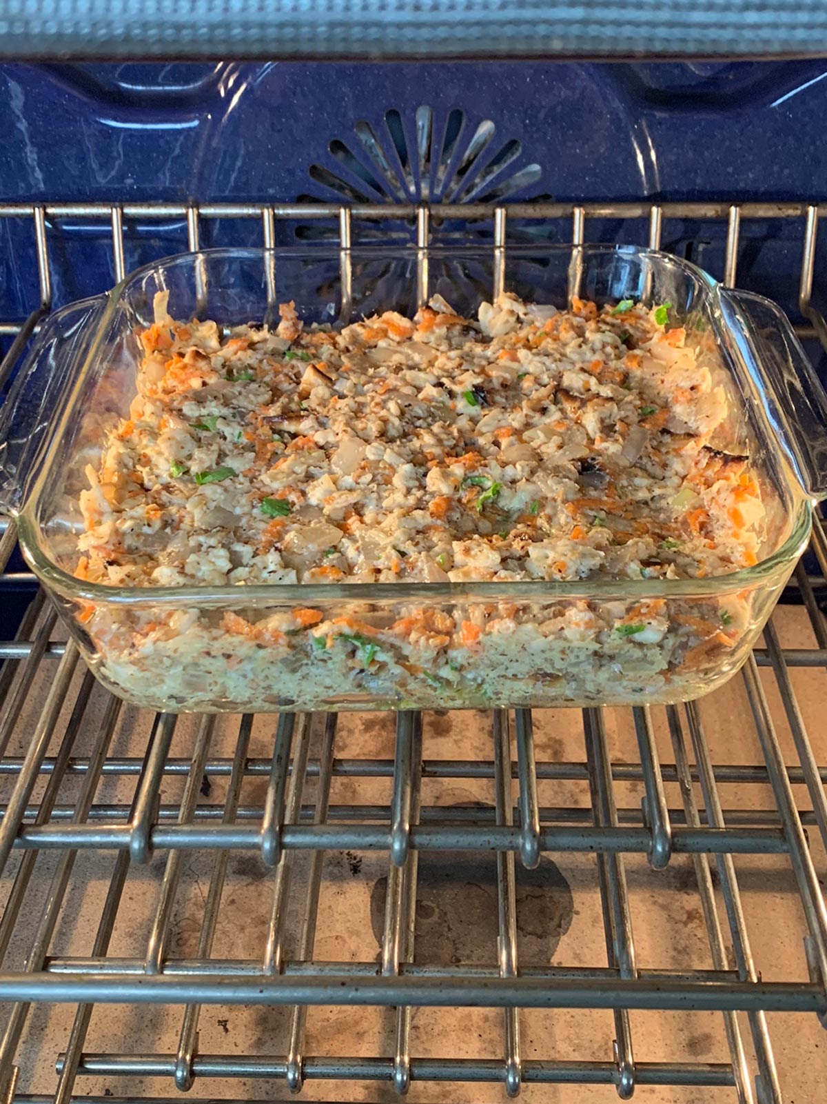 Matzo farfel kugel in a square baking pan in the oven ready to bake.