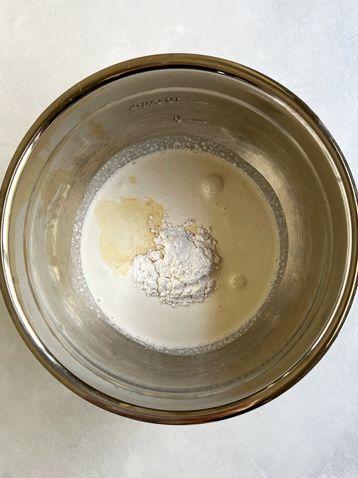Whipped cream ingredients in a large stainless steel bowl.