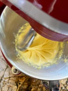 Egg yolks and sugar in process of being mixed in stand mixer.