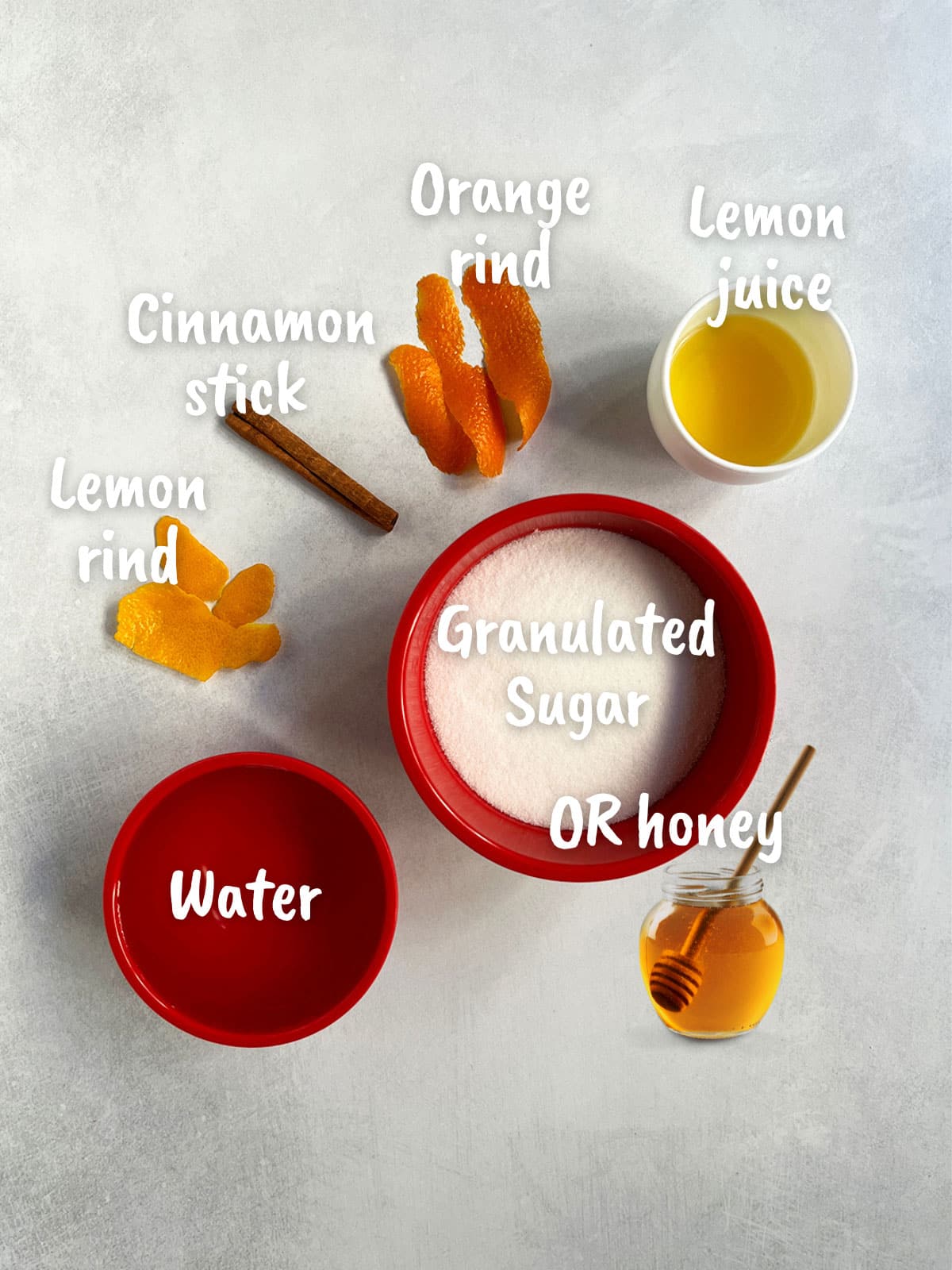 Ingredient shot for honey almond cake syrup showing water, sugar, lemon and orange rind, cinnamon and orange juice plus optional honey substitute.