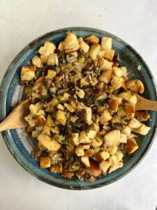 Vegetarian stuffing mixed with two wooden spoons and still in the large blue bowl.