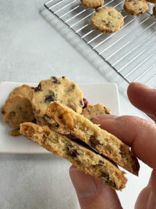 Close up view inside a cookie with a plate of cookies and a cooling rack in the background.