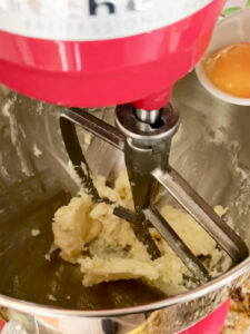 Adding egg yolk to butter sugar mixture in stand mixer for the cranberry and orange shortbread cookie dough.
