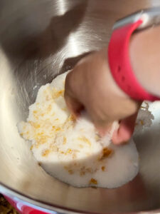 Mixing orange zest and sugar in stand mixer bowl for cranberry orange shortbread dough.