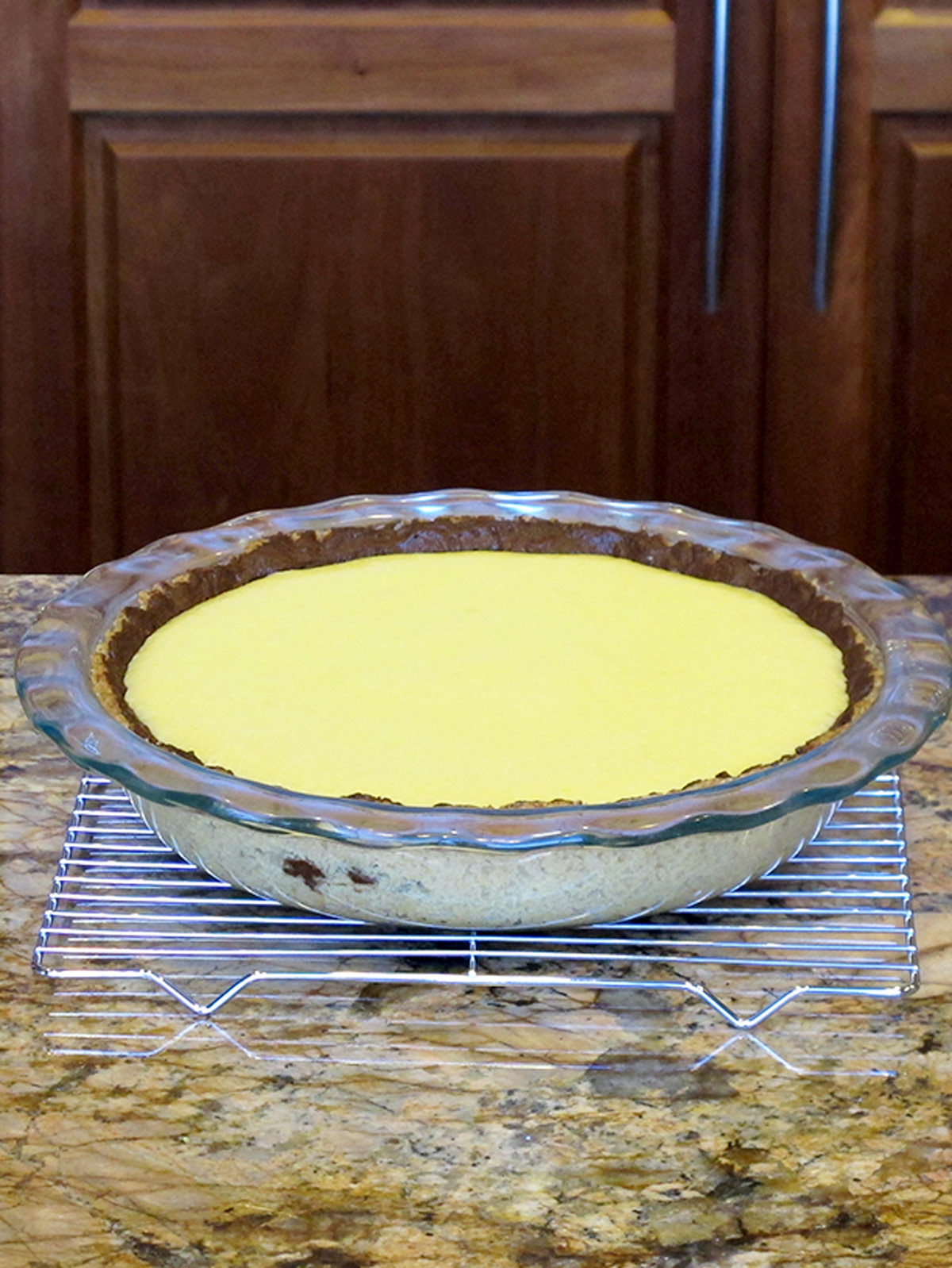 Chocolate key lime pie filling baking sitting on a cooling rack on the counter.