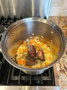 Flanken ribs on top of sauteed mirepoix in stock pot.
