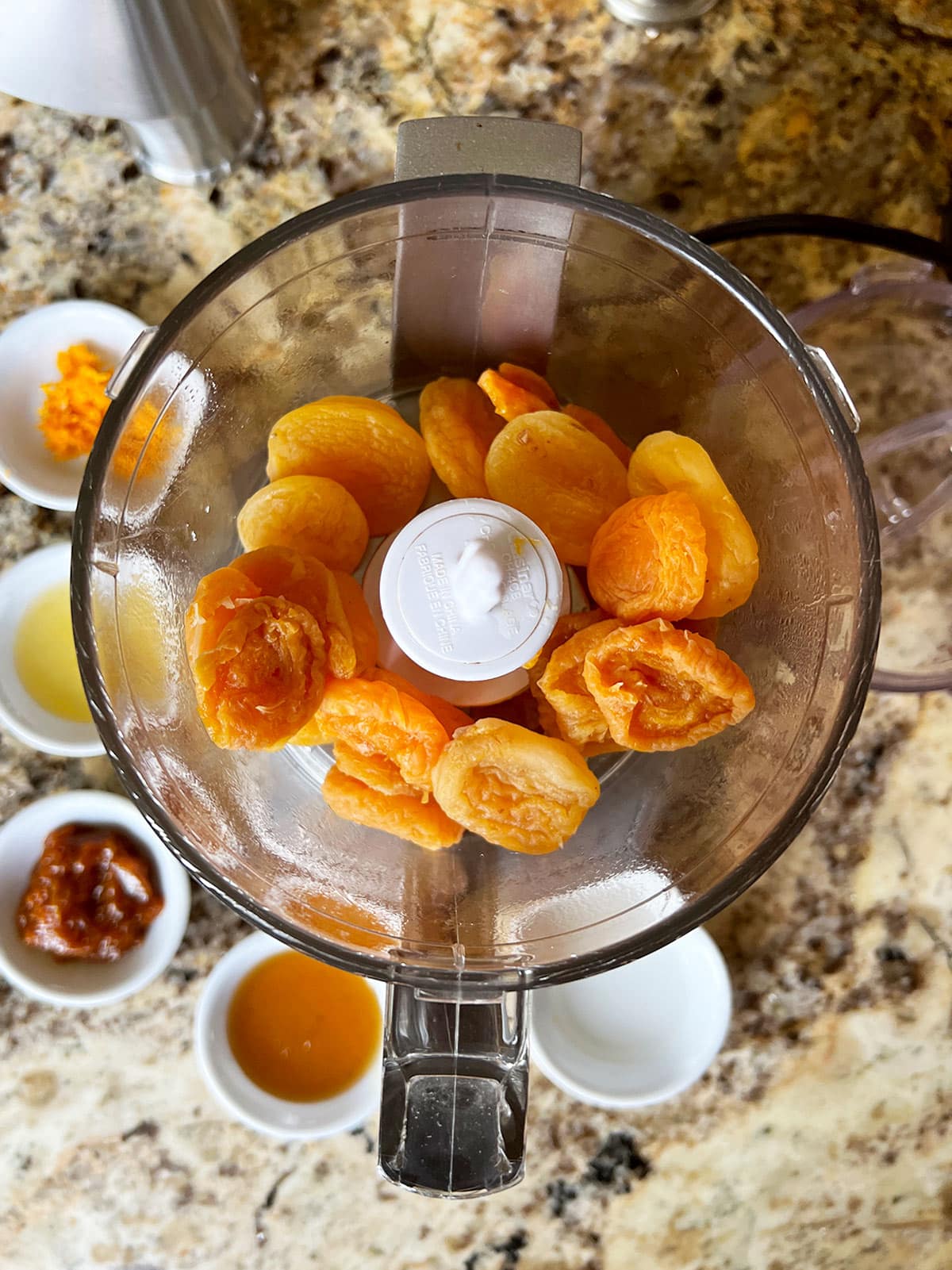 Boiled apricots in food processor with other ingredients ready to be added.