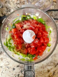 Top down view of salsa about to be processed in the mini food processor.