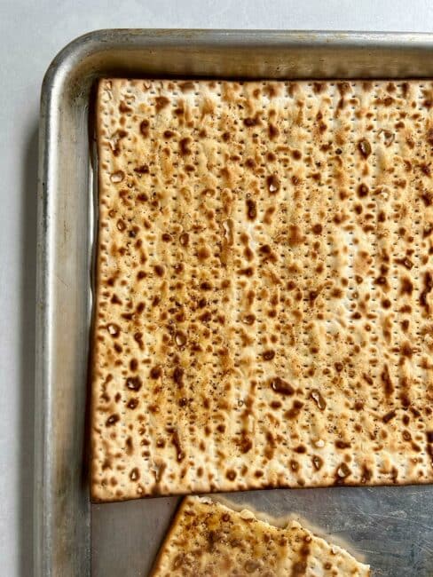 Close up of a baked board of matzo on the sheet tray.