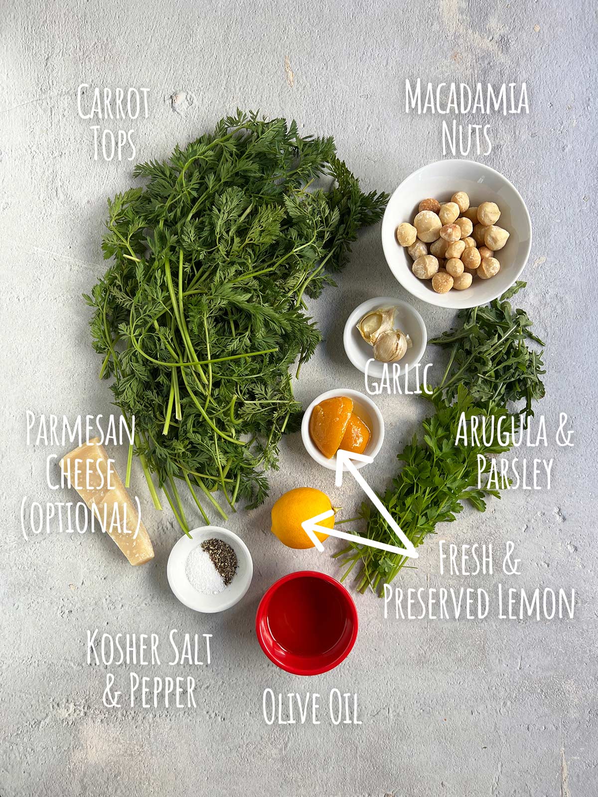 Ingredient shot for carrot top pesto showing carrot tops in the upper left with all the other ingredients to the right of them.
