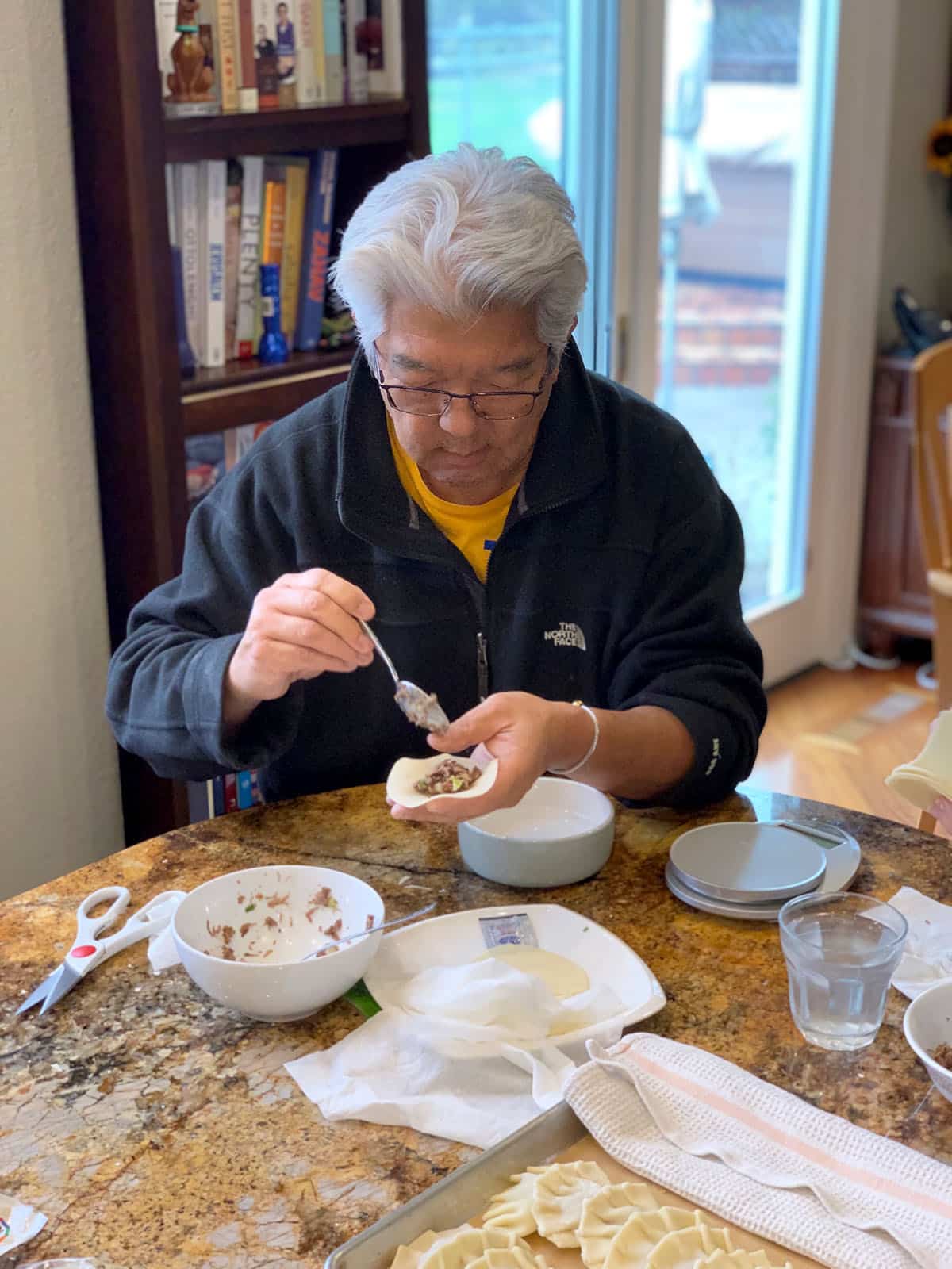Doug folding a Jew Mandu beef dumpling at a kitchen counter.